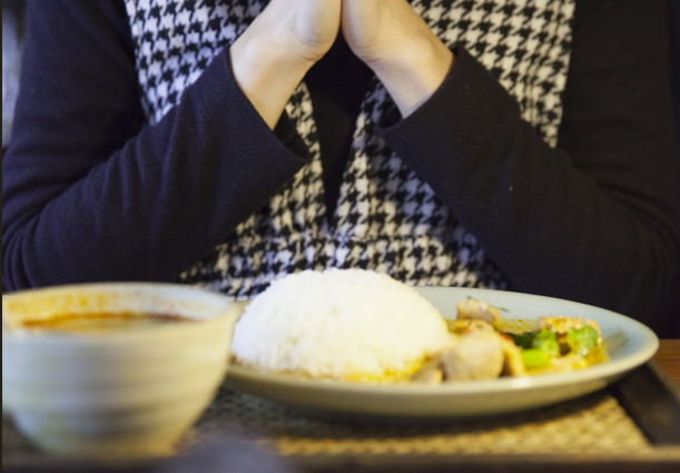 Manos en oración antes de comer